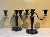 Pair of matching three-arm silver-plated candelabras side by side