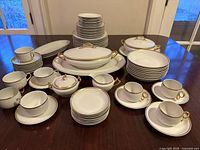 Full lot displaying plates, bowls, cups, covered dishes, platter, sugar and creamer