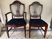 Front view of both mahogany shield back chairs, showing overall style and upholstery