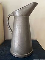 Full left-side view of pewter pitcher showing spout, handle and base