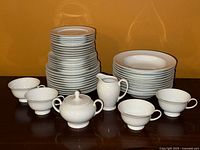 Front view showing full set: plate stacks, bowls, cups, sugar bowl, creamer
