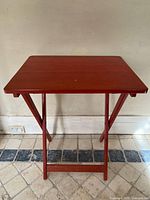 Front view of red folding wooden table