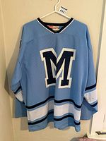 Full front view of light blue St. Michaels Buzzers jersey on hanger