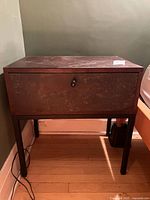 Front view of side table showing drawer, legs, and metal surface