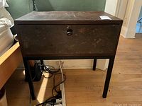 Front view of wood and metal side table with drawer closed