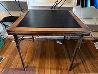 Full view of wooden folding card table standing on floor