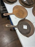 Two rusted Findlay cast iron pans on table