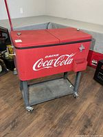 Front view of red metal Coca-Cola cooler on stand