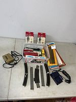 All items laid out: bin of cars & loco, two controllers, loose and packaged track