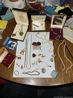 All items overview on table showing lockets, necklaces, cufflinks, brooches, hair comb, earrings, ring