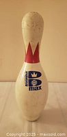 Front view of Brunswick B Max bowling pin showing logo and red crown stripe