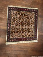 Full view of square Afghan rug on wood floor