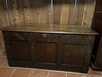 Full view closed oak coffer showing carved panels