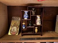overview of shelf with ceramics, packaged dolls visible