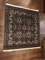 Full view of the Afghan area rug showing overall pattern and fringe