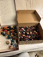 Two open boxes filled with assorted beads