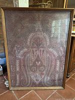 Entire framed shawl leaning against wall showing overall size and frame