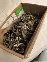 Open cardboard box filled with numerous keys and keyrings