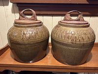 Pair of stoneware urns with lids side by side