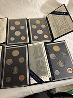 All four proof sets opened to show coins
