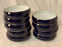 Two stacks of nine dark blue and white bowls