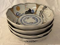 Stack of four scalloped Imari-style bowls showing interior decoration