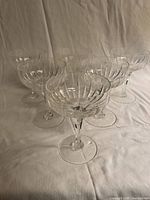 Six Stuart etched crystal coupes arranged on cloth backdrop