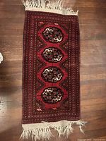 Full view of rectangular red Boukhara rug on wooden floor