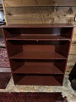 Front view of wooden bookshelf showing four tiers and wear