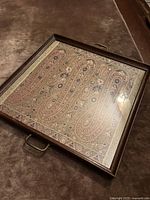 Full view of rectangular wooden tray with glass-covered paisley brocade insert