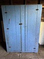 Front view of blue wooden cabinet, doors closed