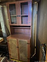 full view of cabinet showing glass top section and cane lower section
