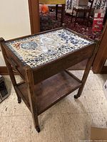 Overall view of walnut side table showing mosaic top and lower shelf