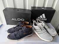 Both pairs of shoes with boxes: Aldo navy sneakers and Adidas grey sneakers