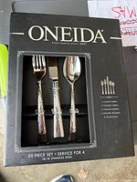 Front of sealed Oneida 20-piece flatware set box showing branding and window with sample pieces