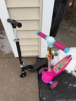 Overview of both scooters leaning against garage corner