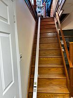 Full length view of Handicare 1100 rail installed on wooden staircase