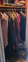 Closet view showing multiple coats and jackets on hangers