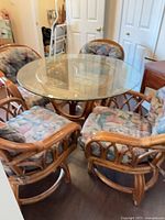 Glass-top rattan dining table with chairs visible (chairs not included)