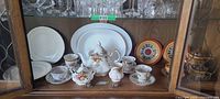 Cabinet shelf with two Old Country Roses teacups and saucers visible among other pieces
