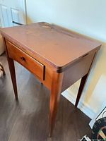 Closed wooden sewing machine cabinet, front view