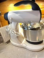 Tilt-head stand mixer with cord, bowl, beaters, manual visible