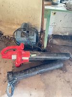 Blue Turbo Dryer Sahara Pro floor-air mover and red corded leaf blower with tubes on floor