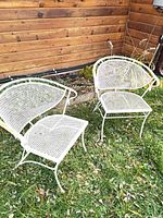 Both metal mesh patio chairs side by side on grass