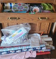 Drawer with ribbon spools, gift bows, tissue, and wrapping accessories