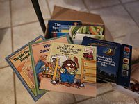 Open box showing front titles Just a Little Critter Collection, Goodnight Goodnight Construction Site, other books visible