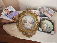 All items: gold framed Holy Family print, plaque, stacks of Joyce Meyer and Joan Hunter books