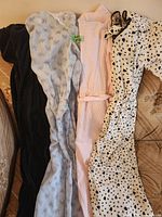 Four garments laid side-by-side on sofa