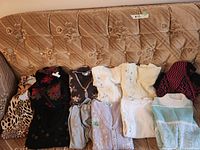 All 12 sweaters and cardigans arranged on couch for overall view