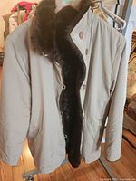 Beige satin side of reversible coat with dark brown faux fur interior visible